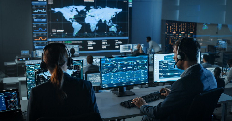 Employees st in front of computer displays